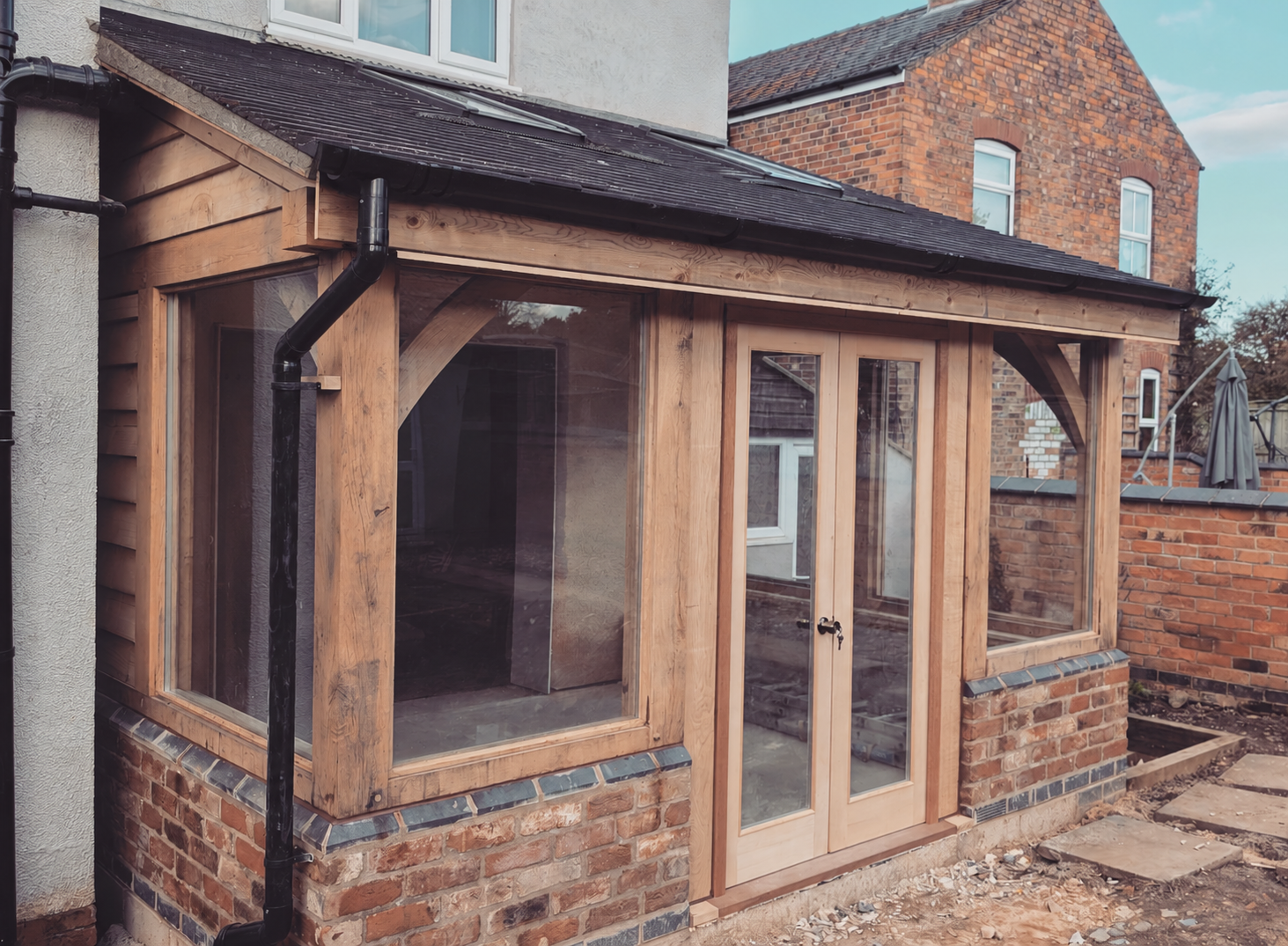 Glazed oak-frame extension with exposed braces and French doors