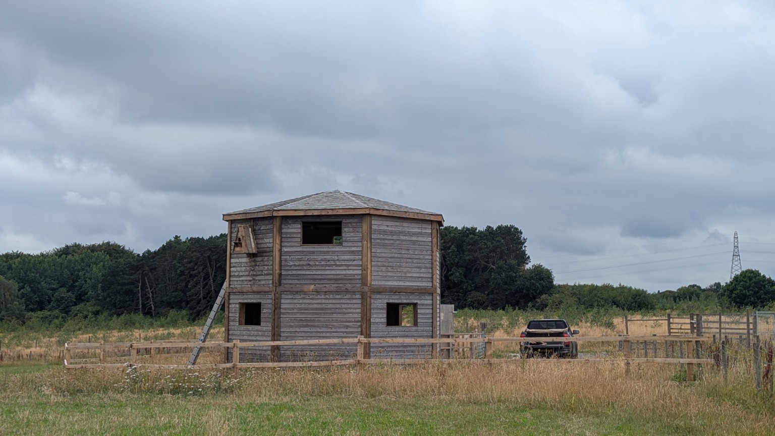 Two-storey octagonal timber structure in an open field