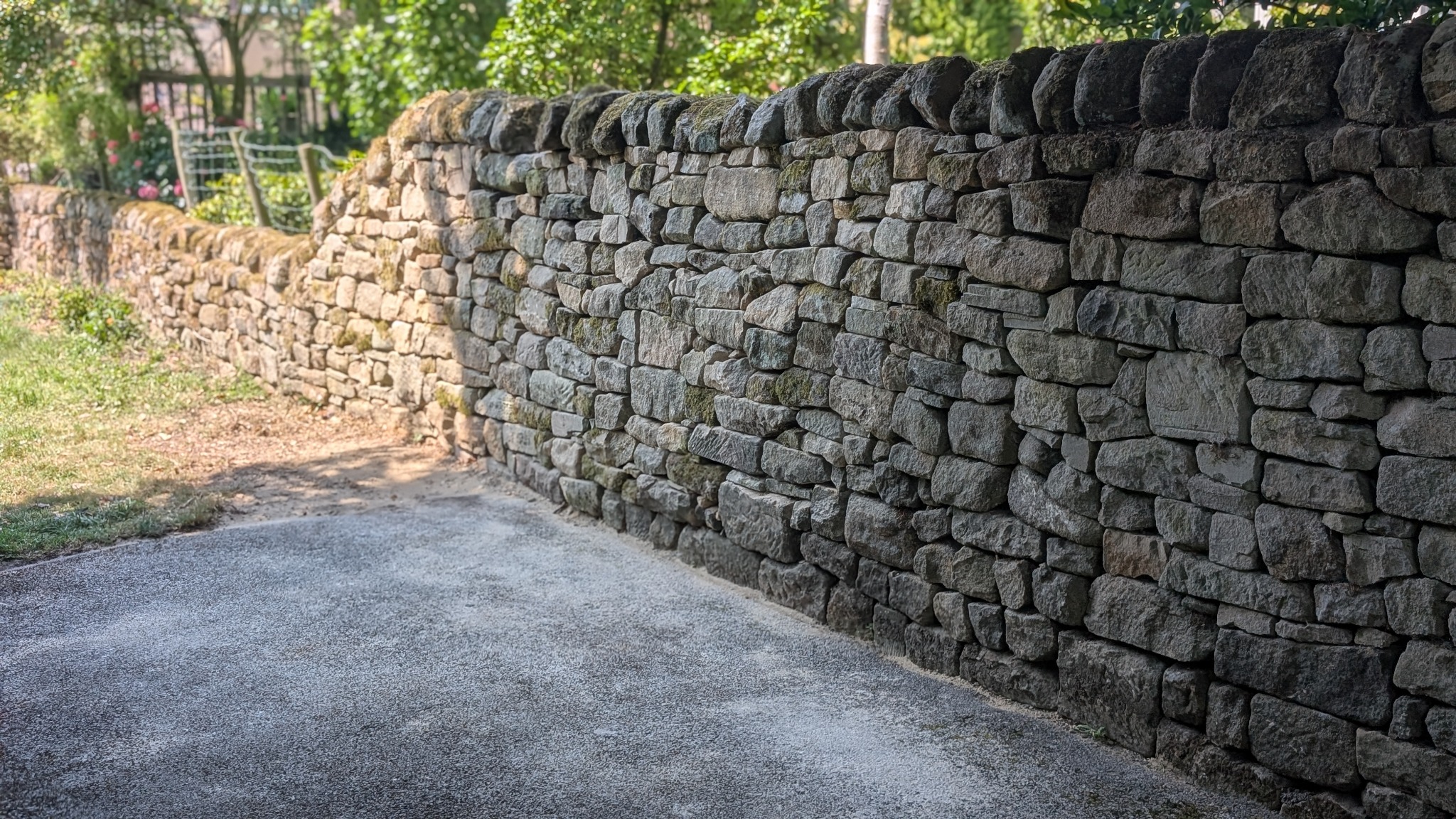 Traditional dry stone garden wall with curved coping stones